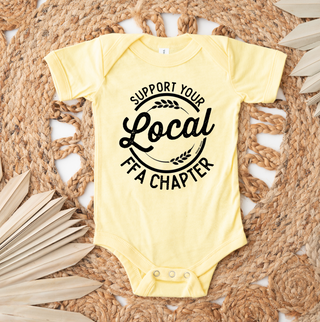 Yellow baby onesie with 'Support Your Local FFA Chapter' text on a woven mat.